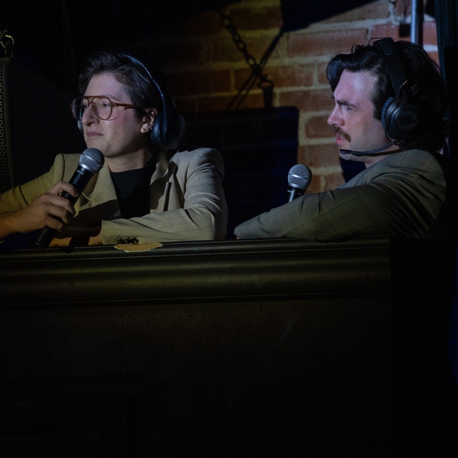 Production image of commentators from Heated Rivalry: The Musical Parody!